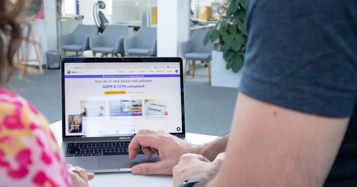 a man and a woman sitting at a table with a laptop