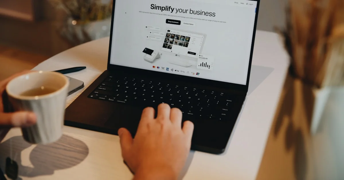 A person sitting at a table using a laptop computer