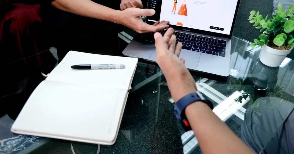 person using macbook pro on white table