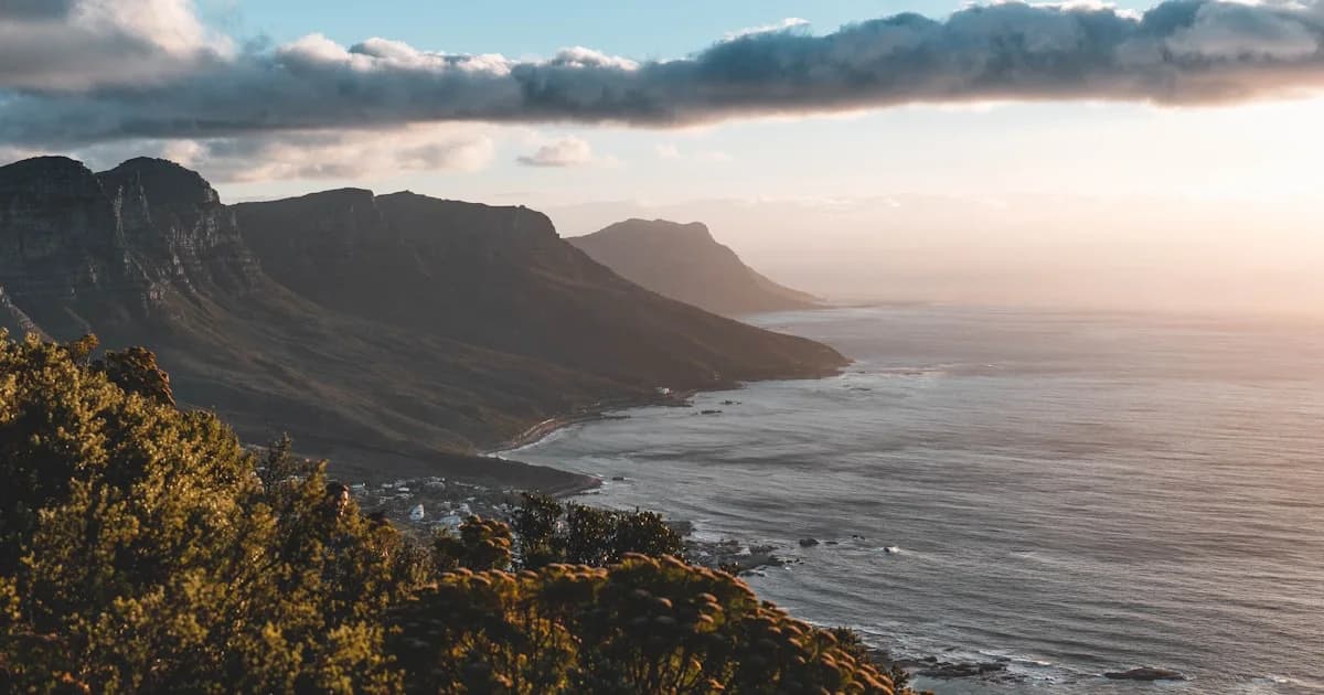 a scenic view of the ocean with mountains in the background