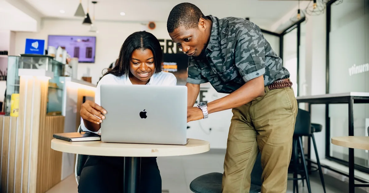 A man and a woman looking at a laptop