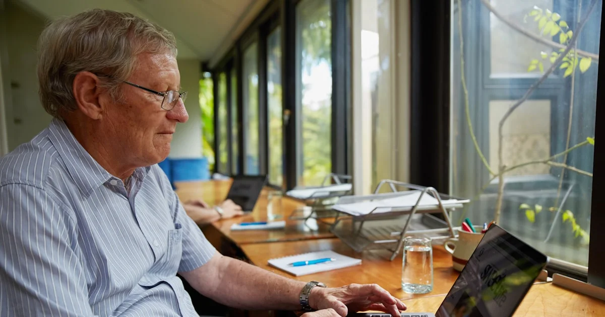 a man sitting at a table using a laptop computer