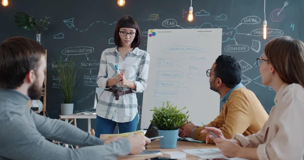 Woman presents to colleagues at a whiteboard meeting.