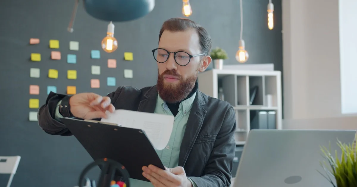 Man in glasses reviewing documents at desk