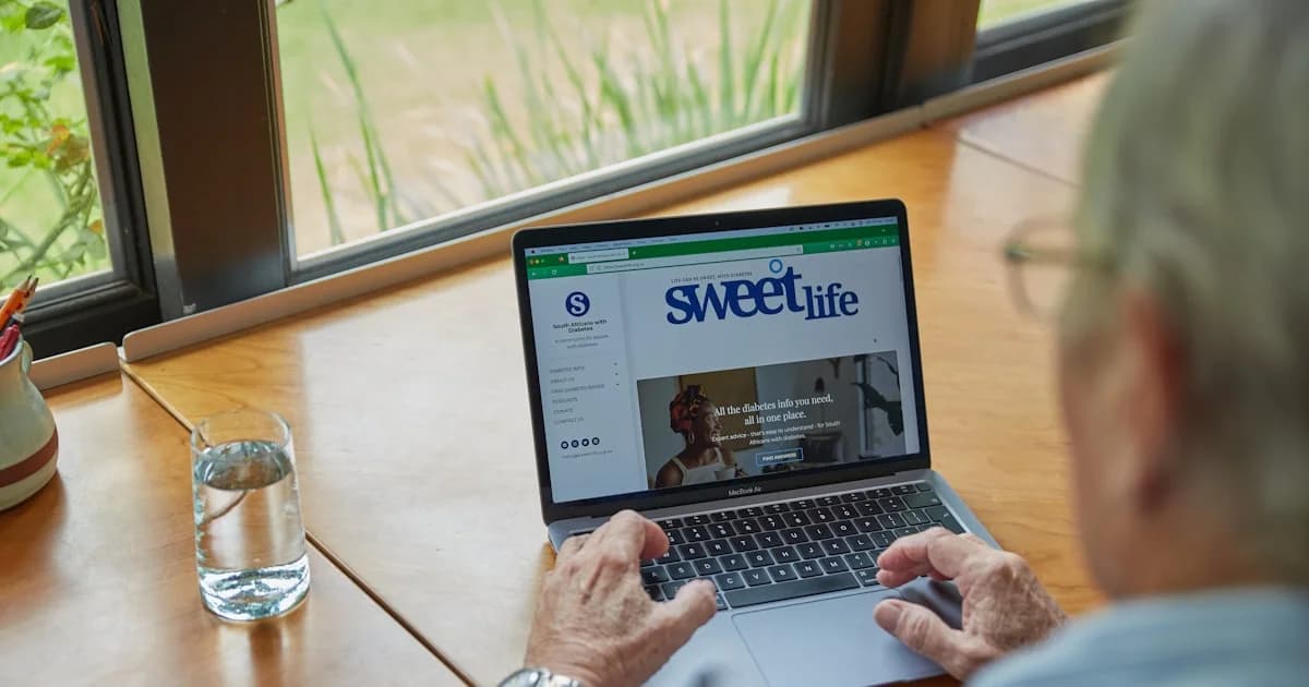 a man sitting at a table using a laptop computer