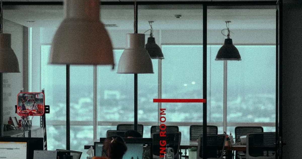 a group of people sitting at a desk with a large window