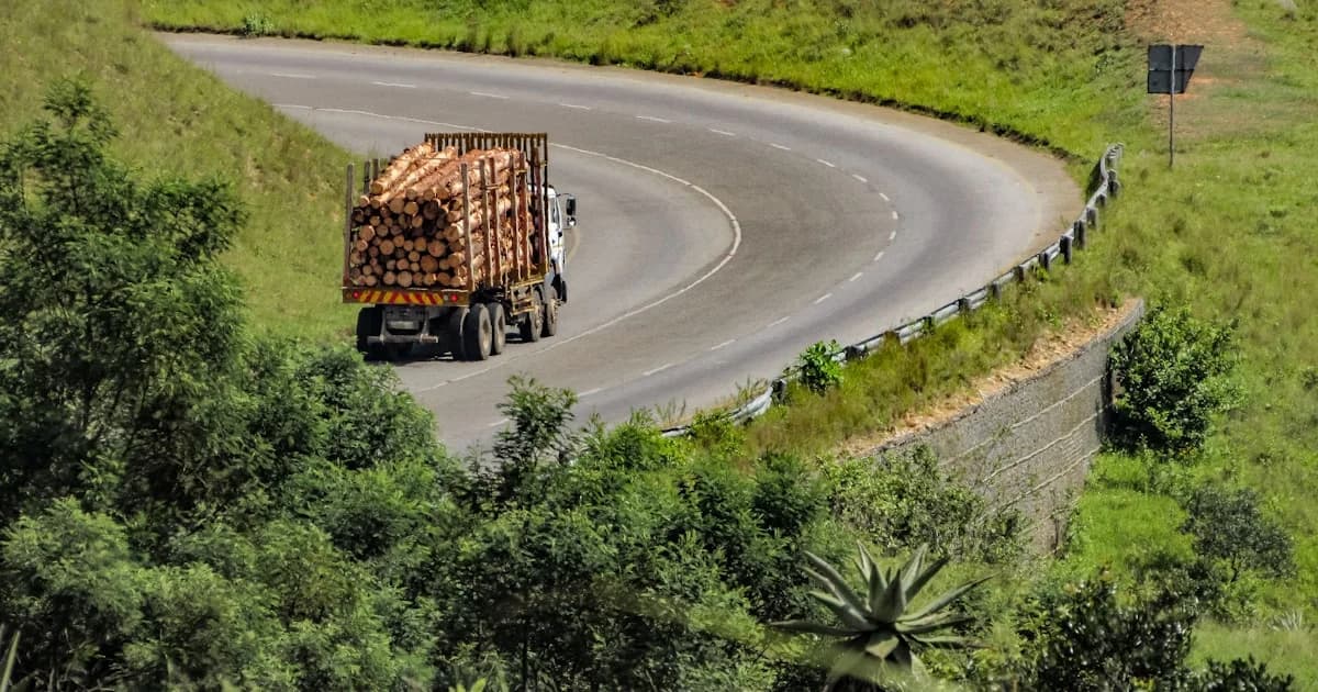 A truck carries cargo on a winding road.