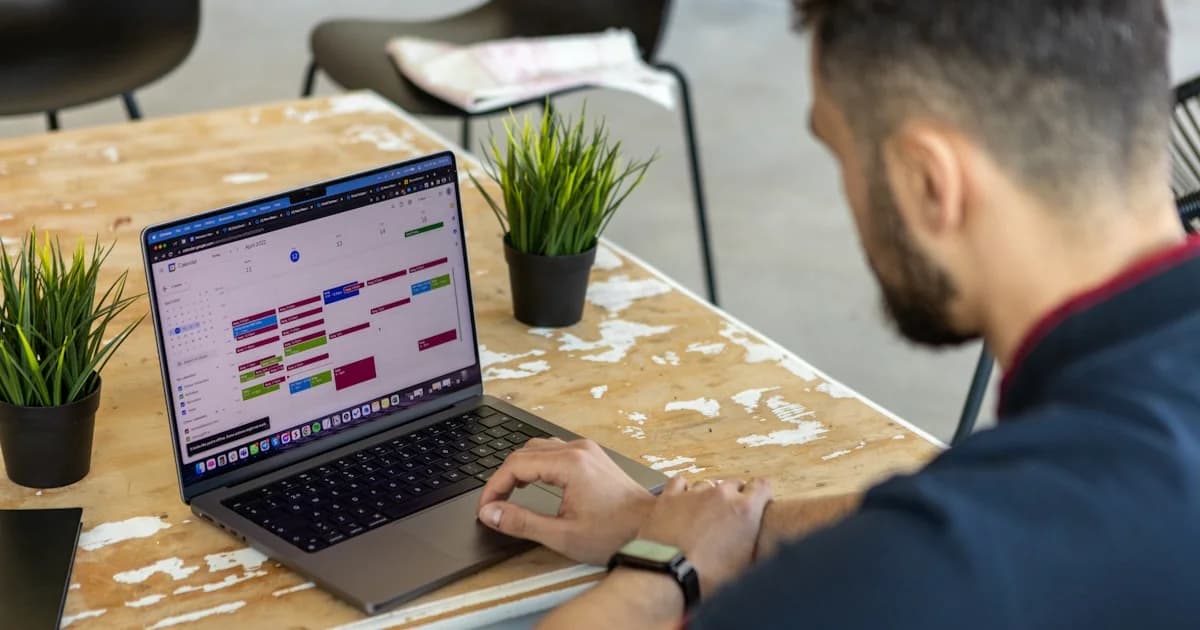 a man sitting at a table using a laptop computer