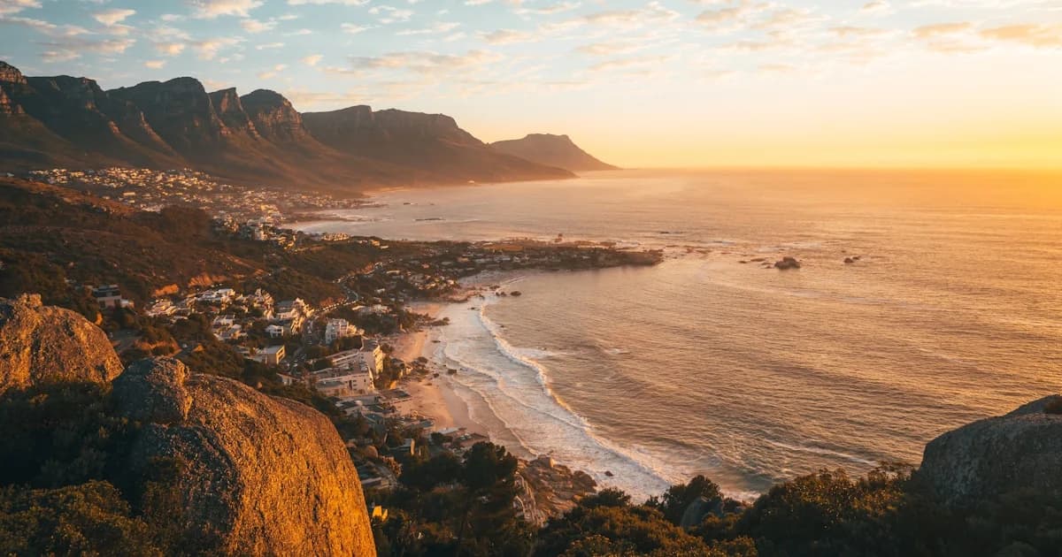 brown rocky mountain beside sea during daytime