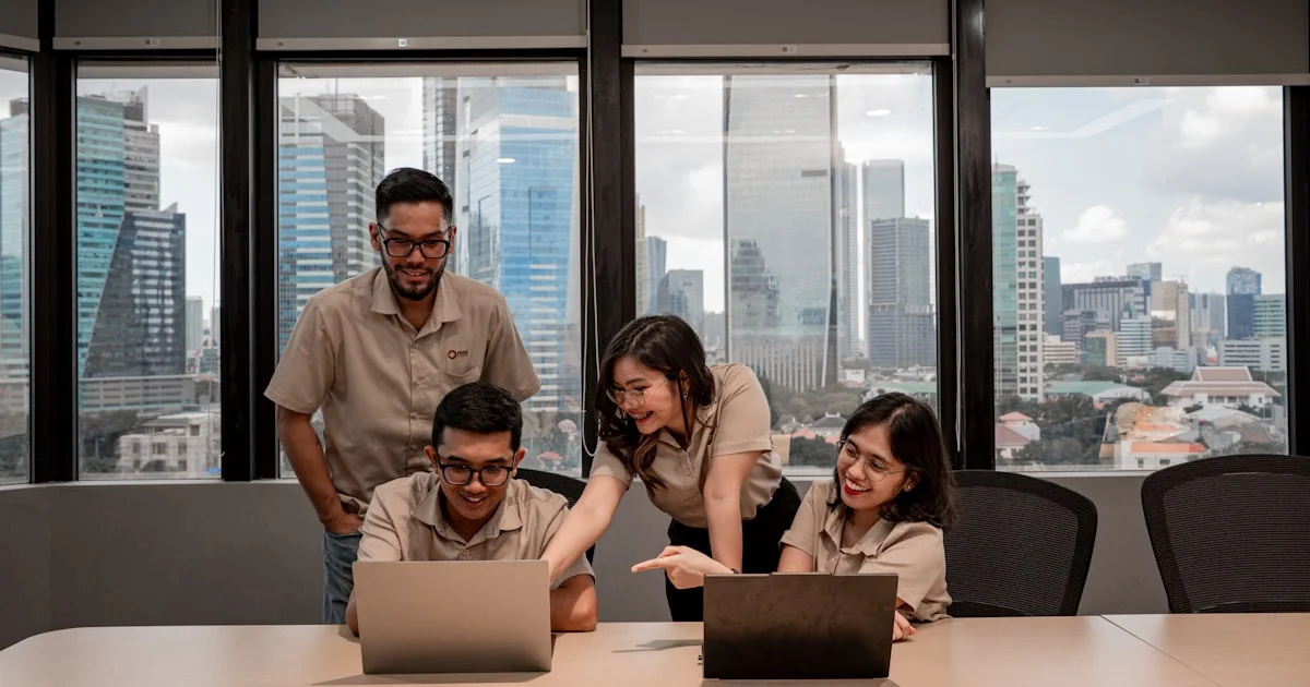Team collaborating on laptops in modern office
