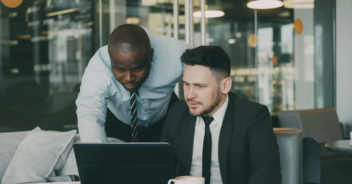 Two businessmen collaborating on a laptop