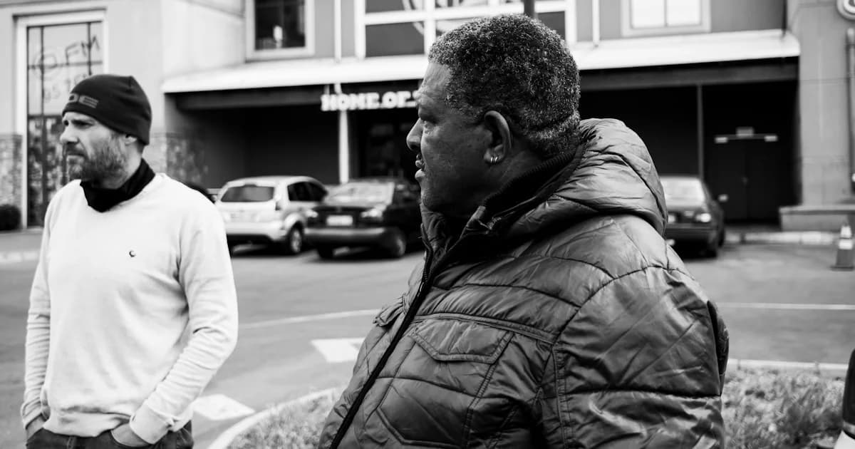 a black and white photo of two men standing in front of a building