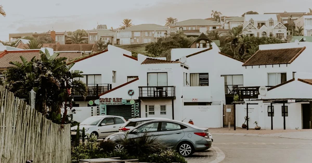 cars parked in front of white concrete building during daytime
