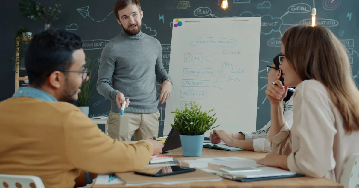 Team collaborating around a whiteboard during a meeting.