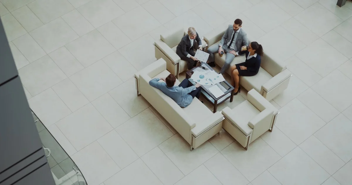 Business people meeting on sofas in a modern lobby.