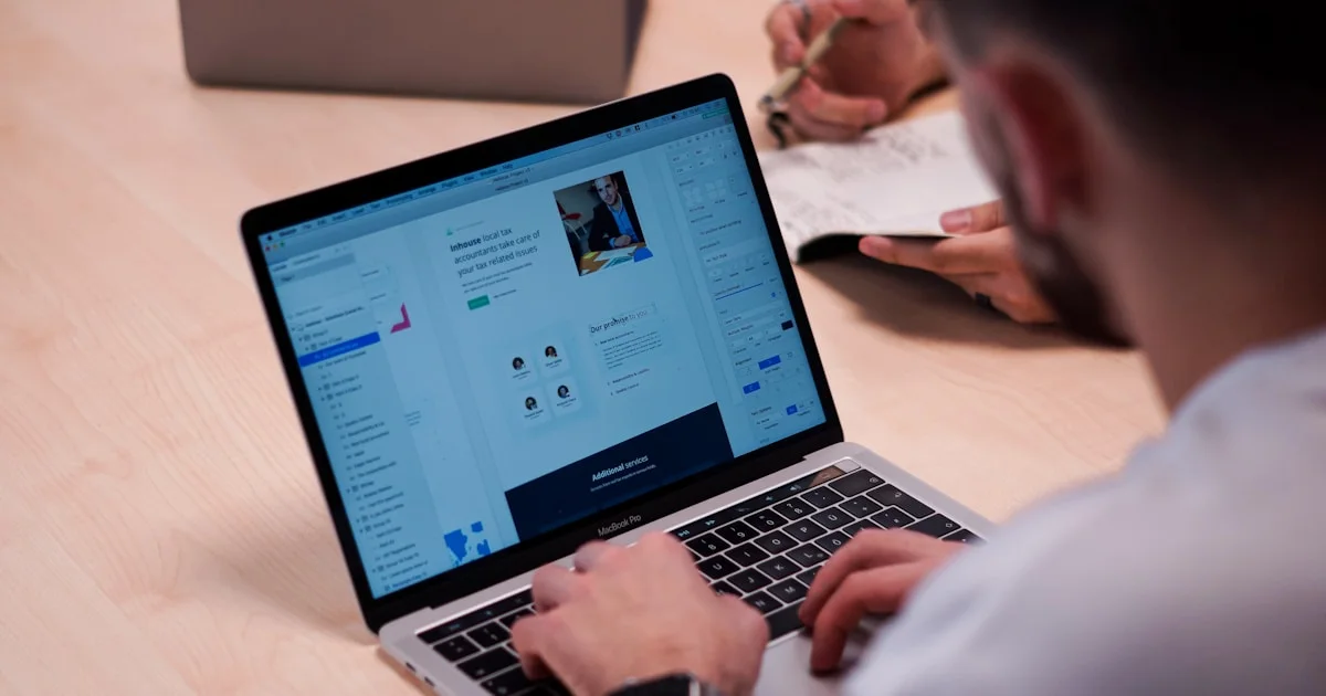 person using macbook pro on table
