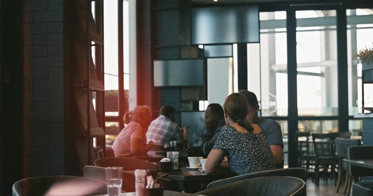 A group of people sitting at a table in a restaurant
