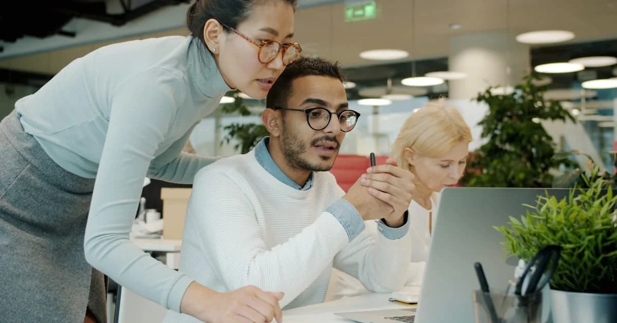 Two colleagues collaborating on a computer screen.