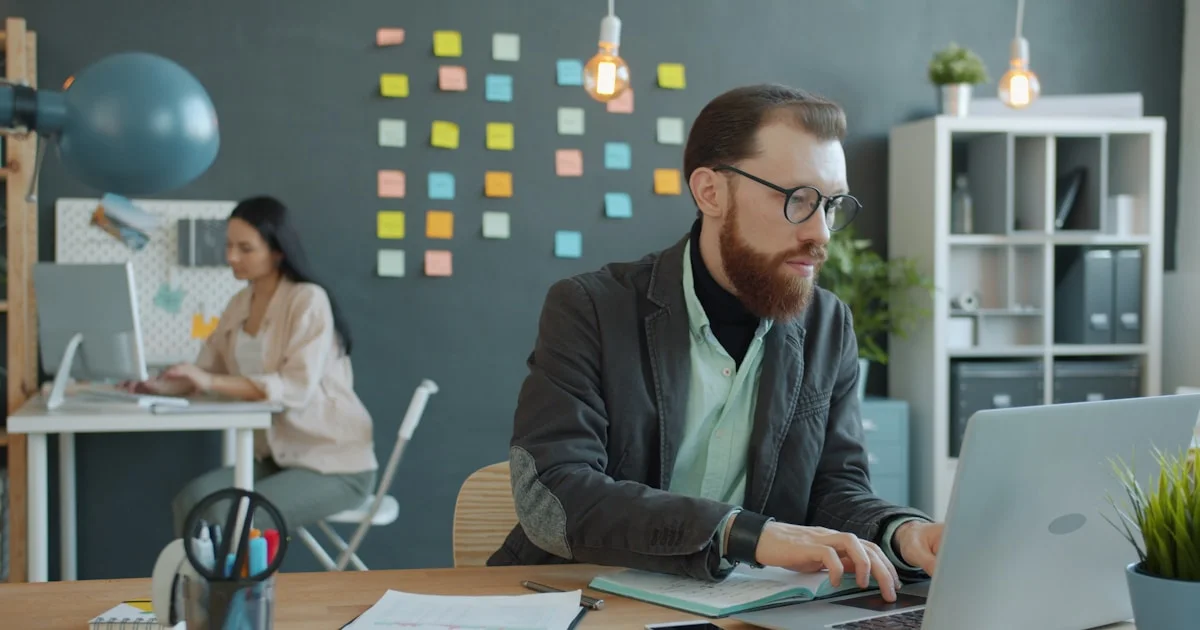 Man and woman working in modern office setting.