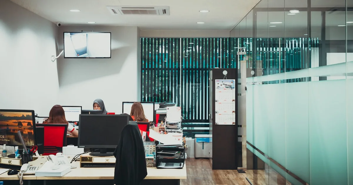 a group of people sitting at desks in an office