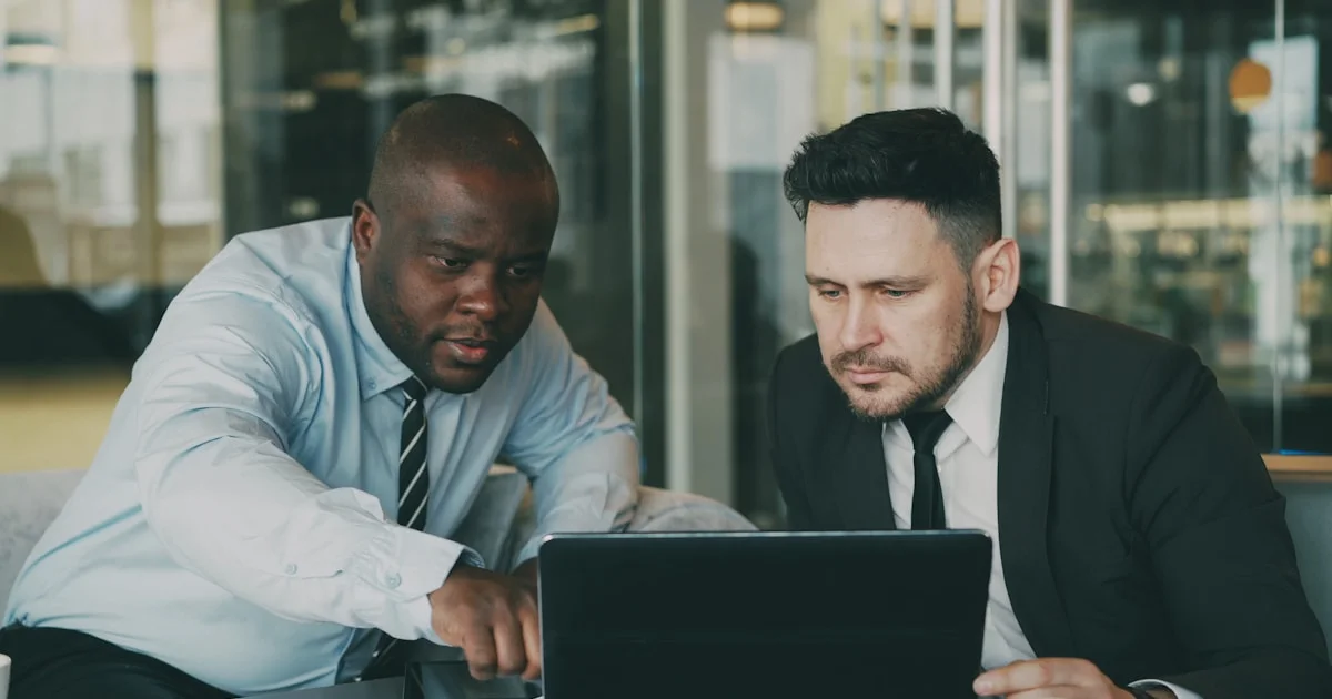 Two men looking at a laptop together